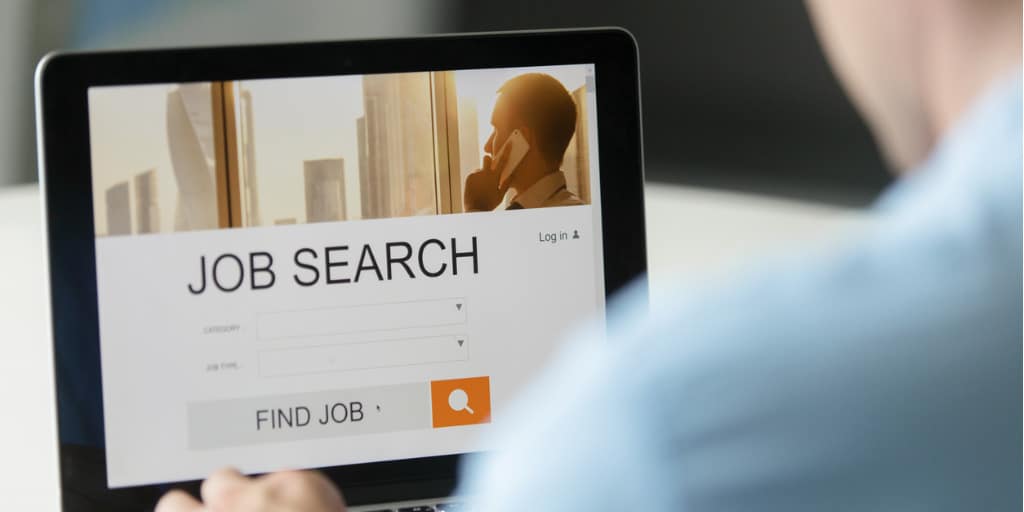 a male carrying out job search on his laptop