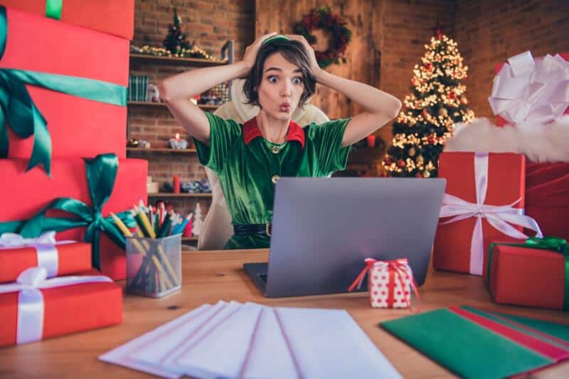 elf checking present list on laptop